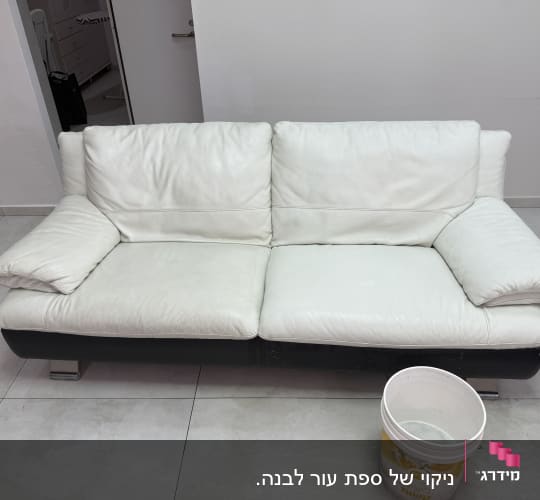 ספה לבנה ודלי עם מים לניקוי